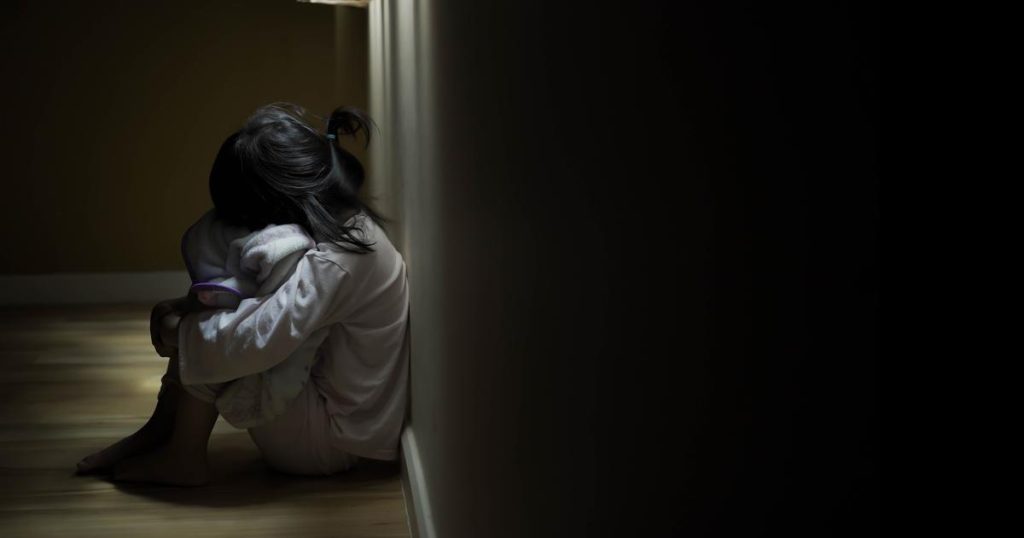 Squat single child sit near window, sad lonely in dark night ind